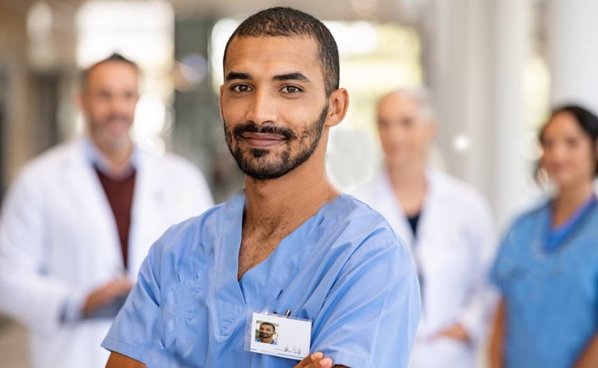 Male Doctor in the foreground with medical professionals in the background