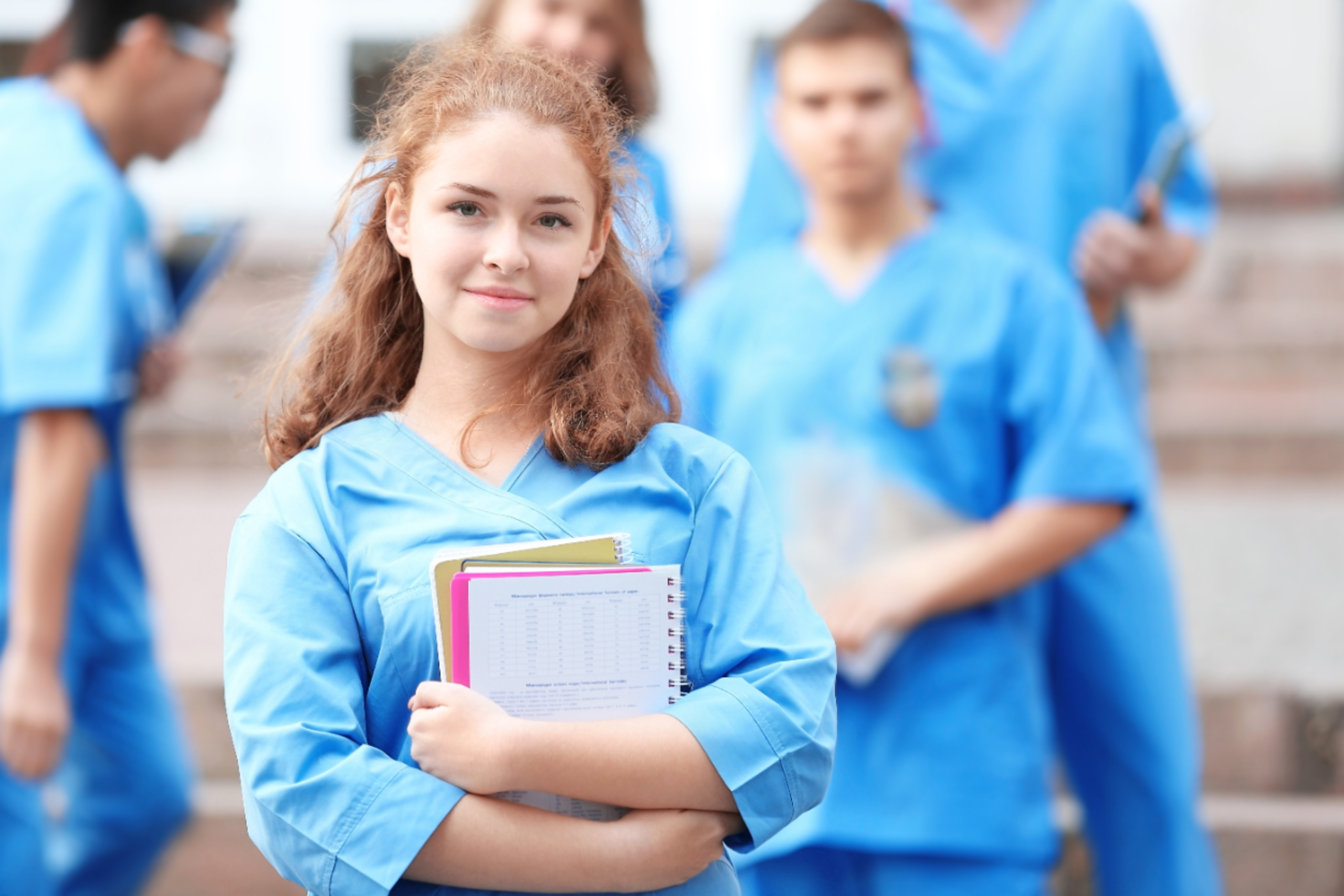 Young female nursing student in the foreground with other students in the background