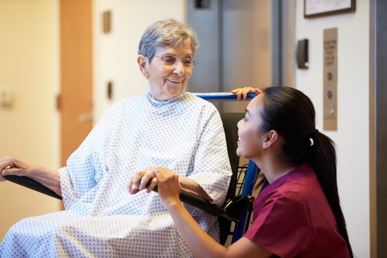 Female patient being assisted by a health care staff member