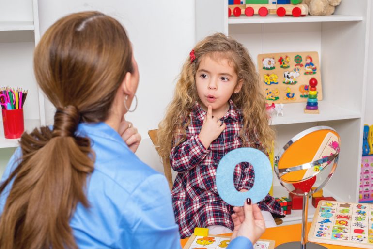 Speech and language therapist working with a young girl