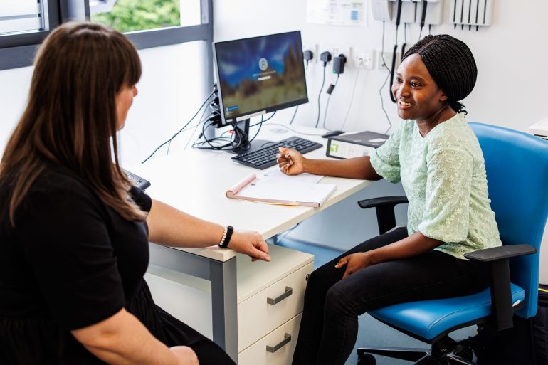 Female doctor speaking with a female patient in her office. 