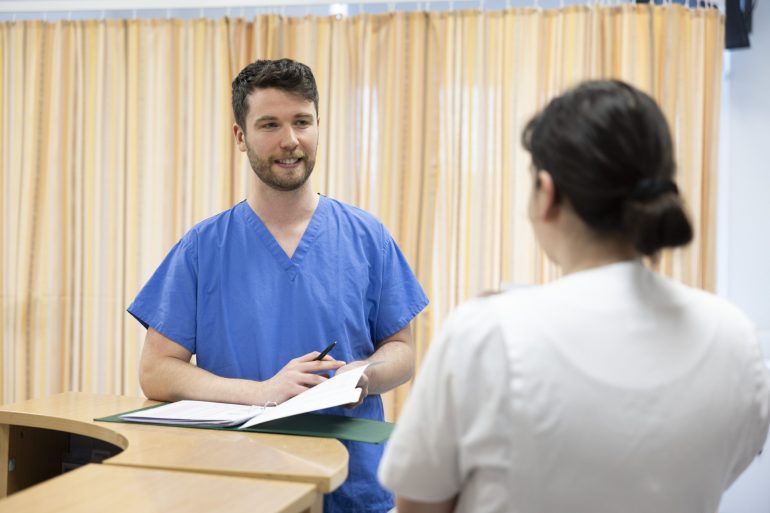 Male doctor speaking with a hospital staff member 