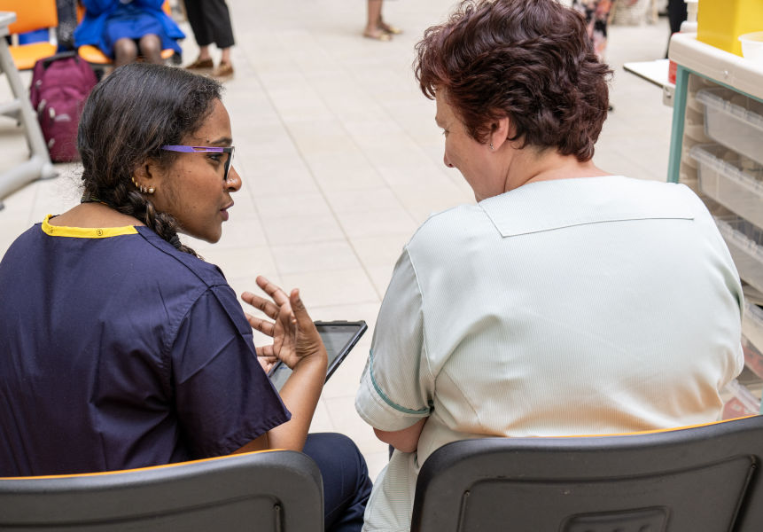 two healthcare colleagues talking in the workplace
