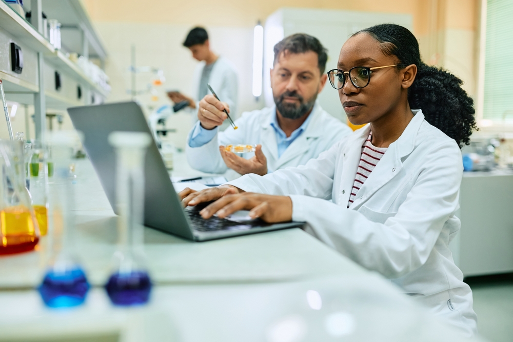 African American Biochemist working with a colleague in a lab
