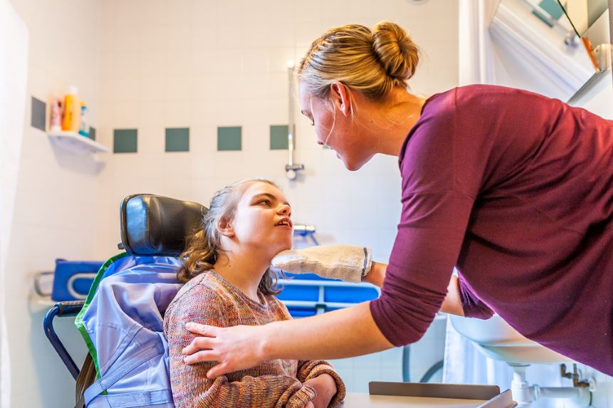 nurse assisting a young girl in a wheelchair
