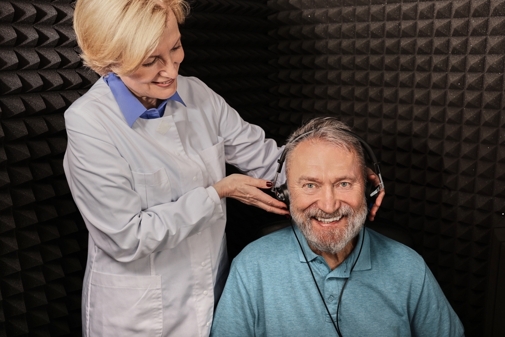 Audiologist with patient in Soundproof room. Hearing Check-up